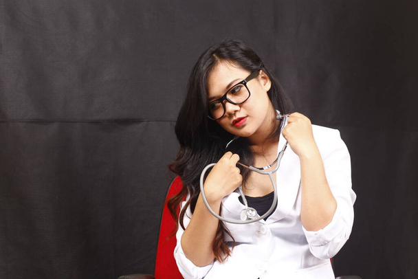 indonesia medico donna in possesso di stetoscopio, relazione su sfondo bianco - Foto, immagini