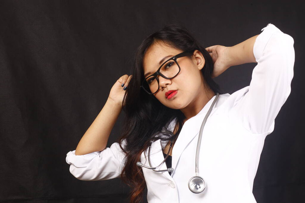 indonesia woman doctor holding stethoscope, report on white background - Photo, Image