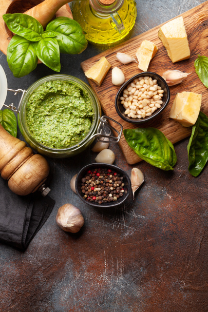 Homemade pesto sauce with basil leaves, pine nuts, parmesan and garlic. Top view flat lay with copy space - Photo, image
