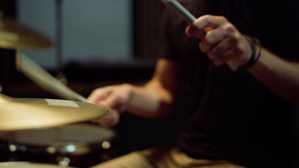 Unerkennbarer Schlagzeuger, der im Studio auf einem Schlagzeug spielt. Musiker tritt solo auf - Foto, Bild
