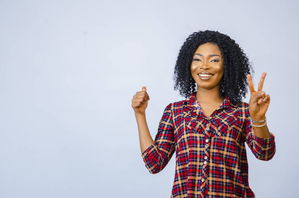 A cheerful African female doing thumbs up - blank space for text - Photo, image