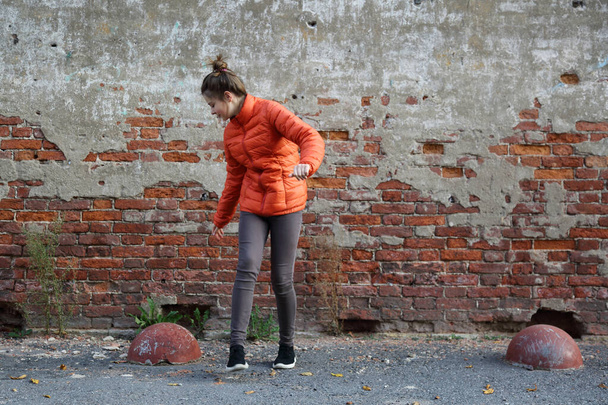 Funny active teen gitl against red brick wall outdoor. Selected focus. - Valokuva, kuva