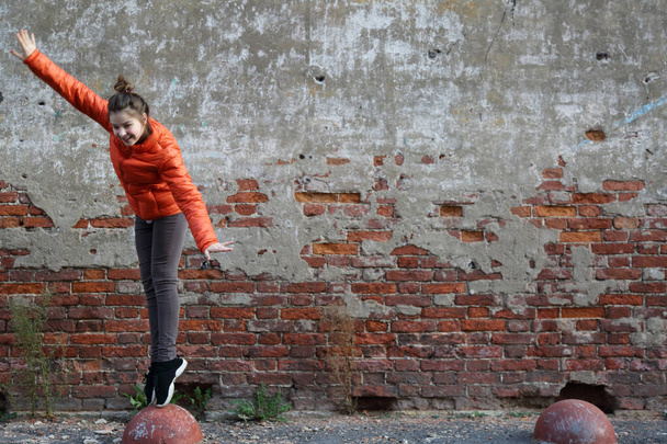 Funny active teen gitl against red brick wall outdoor. Selected focus. - Фото, зображення