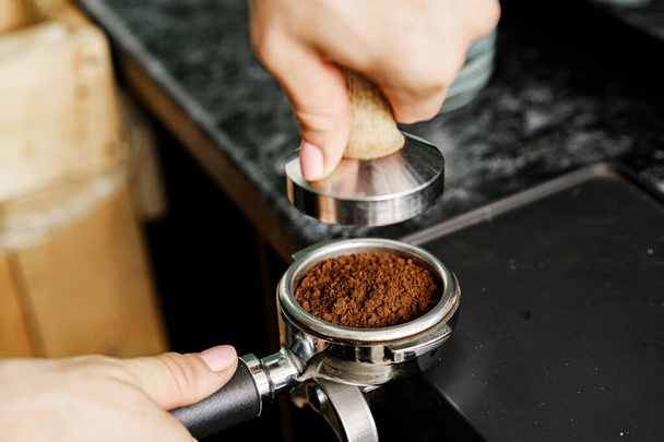 Woman coffee shop worker preparing coffee on professional coffee machine - Photo, image