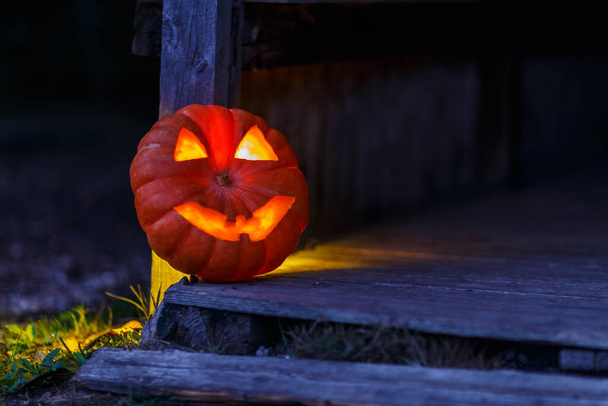 An illuminated Halloween pumpkin in the backyard - Zdjęcie, obraz