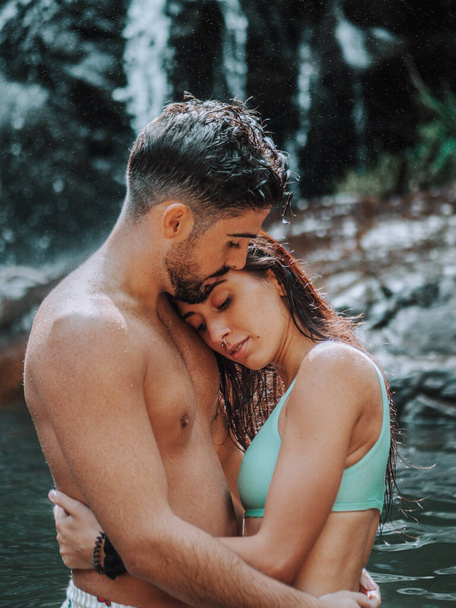 A vertical shot of a Caucasian couple being affectionate at a river - Φωτογραφία, εικόνα
