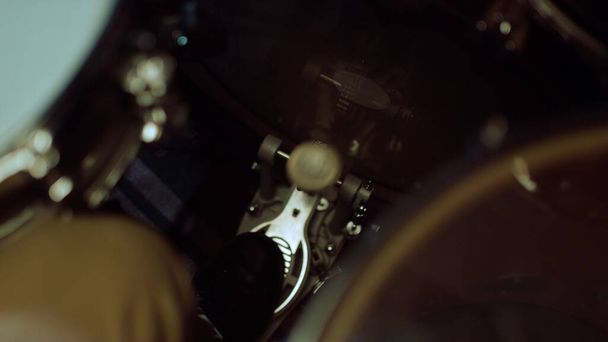 Барабанщик б'є ритм у студії. Чоловік ноги натискає педаль барабана в приміщенні
. - Фото, зображення