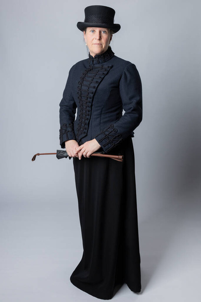 A middle-aged woman wearing a Victorian riding habit and holding a riding crop - Φωτογραφία, εικόνα