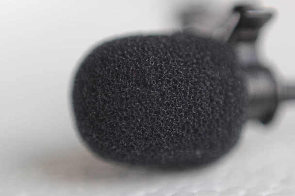 A closeup shot of a lapel microphone on a white surface - Φωτογραφία, εικόνα