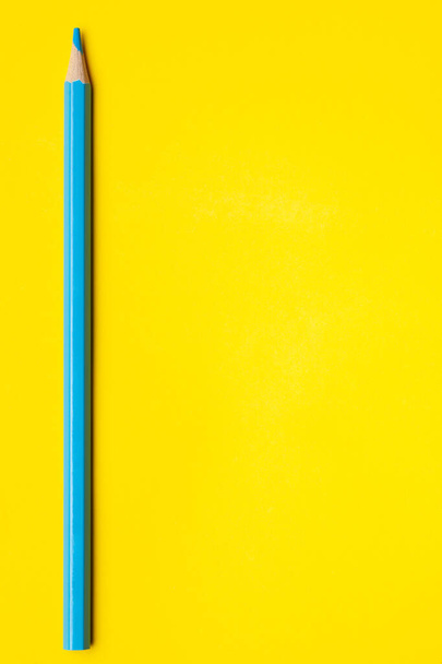 vertical blue sharp wooden pencil on a bright yellow background, isolated, copy space, mock up - Fotografie, Obrázek