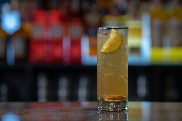 A closeup shot of original alcoholic cocktails with lemon garnish in a bar table - Фото, зображення