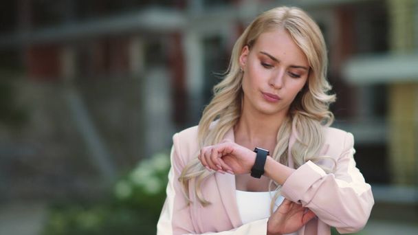 Closeup business woman looking at smart watch. Woman looking at watch outdoor - Photo, Image