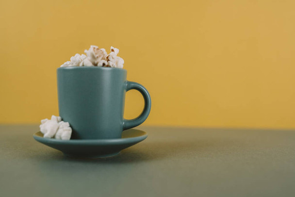 A closeup shot of a coffee cup filled with popcorn and with space for text - Foto, afbeelding