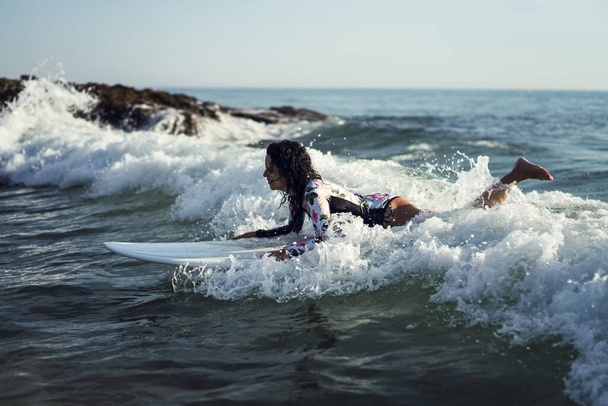 An attractive female surfing on the waves - Фото, изображение