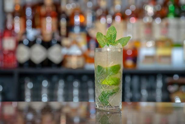 A closeup shot of a glass of refreshing cocktail in a bar - Fotó, kép
