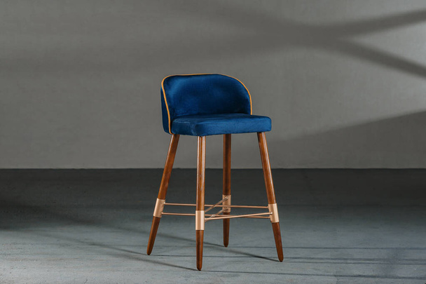 A blue dining room chair in a studio with gray walls - Photo, image