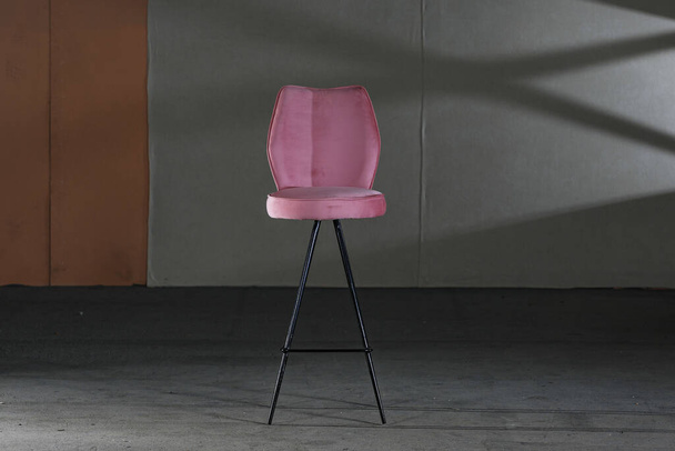 A high modern chair with long legs and purple soft upholstery - Фото, зображення