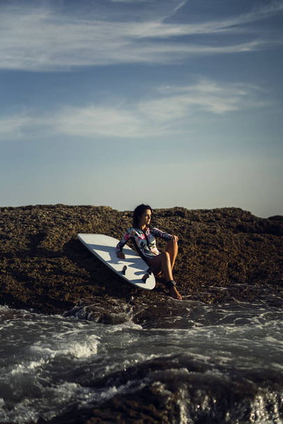 A vertical shot of a caucasian woman surfing - Foto, Imagen
