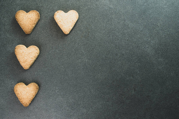 Une vue de dessus de biscuits en forme de cœur sur une surface sombre - concept d'amour - Photo, image