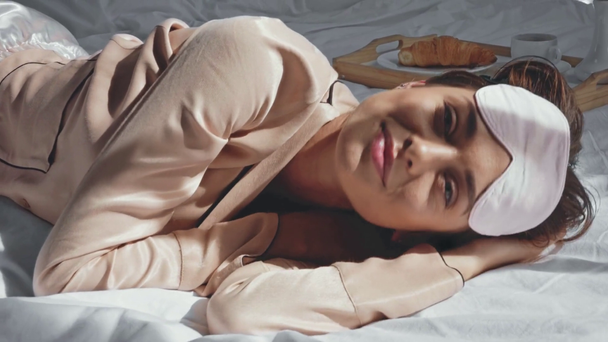 gelukkig vrouw geeuwen en kijken naar camera in bed - Video