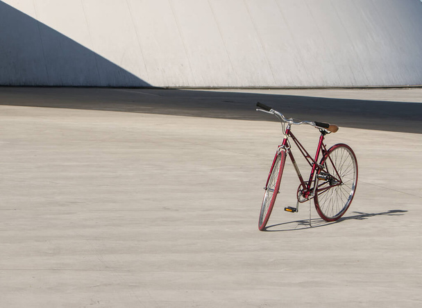 A red bicycle parked during the daytime - Foto, afbeelding