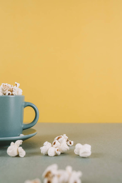 A vertical shot of a coffee cup filled with popcorn and with space for text - Foto, Imagem