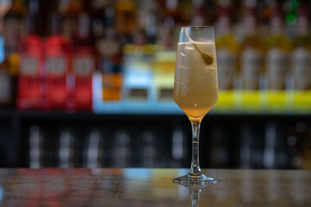 Крупный план бокала коктейля со льдом с оливками на барной стойке - Фото, изображение