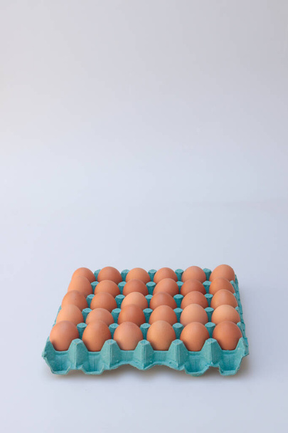Pionowe ujęcie pudełka z kurzymi jajami odizolowanego na szarym tle - Zdjęcie, obraz