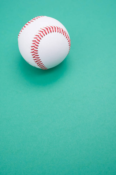 A vertical shot of a baseball ball isolated on turquoise background - Fotó, kép