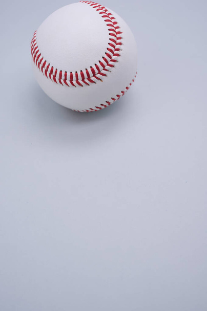 A vertical shot of a baseball ball isolated on light blue background - Foto, Bild