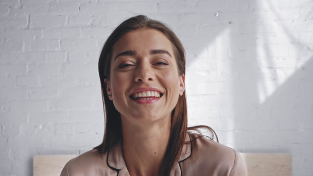 hymyilevä nainen vahvistamisesta hiukset ja katsot kameraa - Materiaali, video