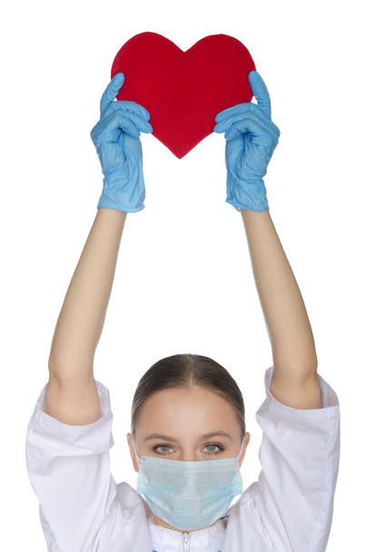 Nurse in  mask held up a heart symbol - Photo, image