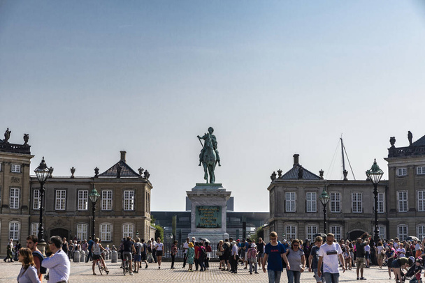 Copenhagen, Denmark - August 27, 2019: Equestrian statue of the King Frederick V in the centre of the Amalienborg Palace Square with people around in Copenhagen, Denmark - Fotografie, Obrázek