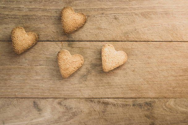 A top view shot of heart-shaped cookies on a wooden surface - concept of love - Photo, Image