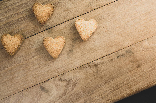 A closeup shot of hearth shaped cookies on wooden background - Photo, image