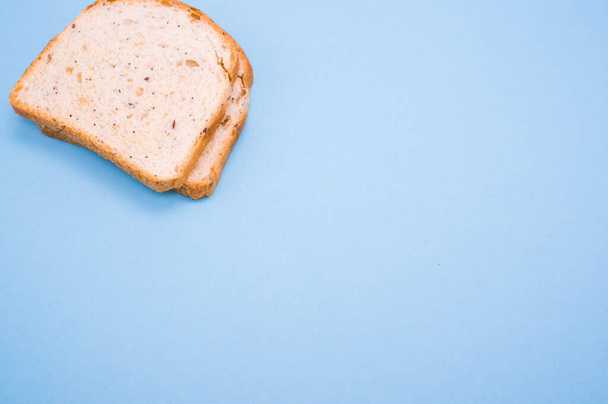 Two slices of bread isolated on turquoise background - Foto, Imagen