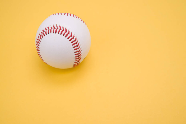 A baseball ball isolated on yellow background - Foto, Imagen