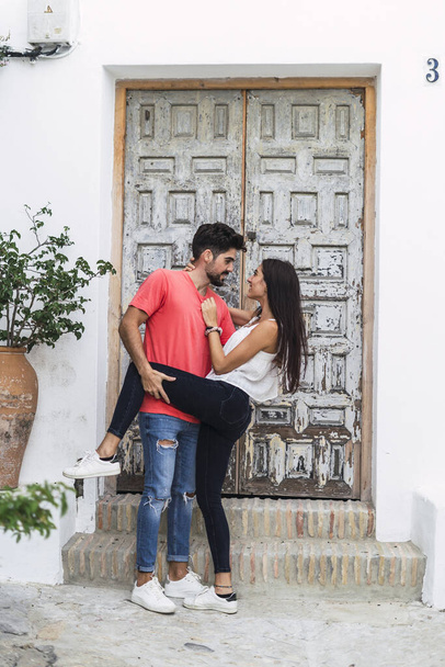 A vertical shot of an affectionate couple standing near a building - Foto, imagen