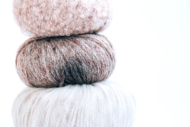 Three balls of yarn in nude shades stacked on top of each other on a white background. Craft on white background. Knitwear as a concept of female hobby - Fotó, kép