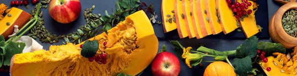 Festive autumn decor from raw pumpkins, berries and leaves. Top view, panorama, banner. - 写真・画像