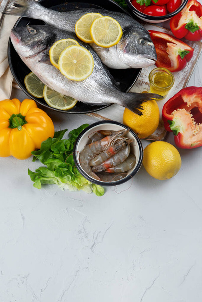 Raw dorado fish with vegetables. Top view, copy space - Zdjęcie, obraz