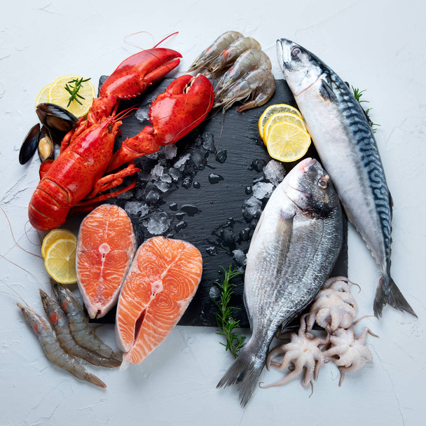 Assortment of fresh raw fish and seafood. Healthy and balanced diet or cooking concept. Top view - Φωτογραφία, εικόνα