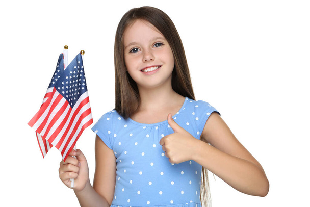 Young girl holding american flags and showing thumb up on white background - Valokuva, kuva