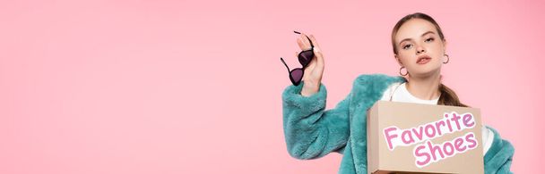 panoramic crop of woman holding sunglasses and box with favorite shoes lettering isolated on pink, black friday concept - Photo, Image
