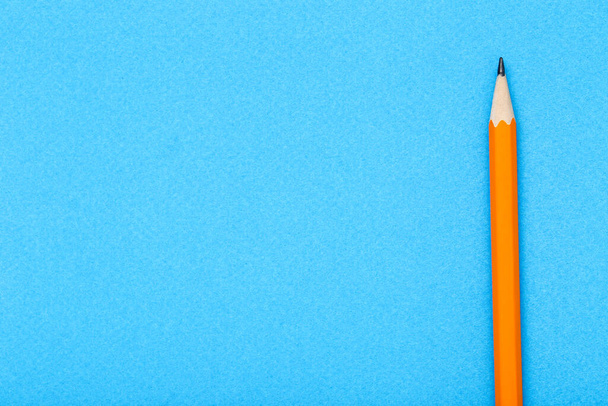 Yellow pencil on blue background - Foto, Imagen