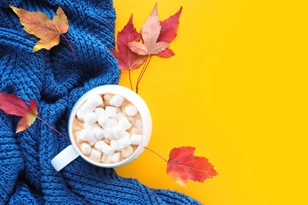 秋の構図。青いニットセーター、赤と黄色のカエデの葉とマシュマロとコーヒーのカップ。コピースペース - 写真・画像