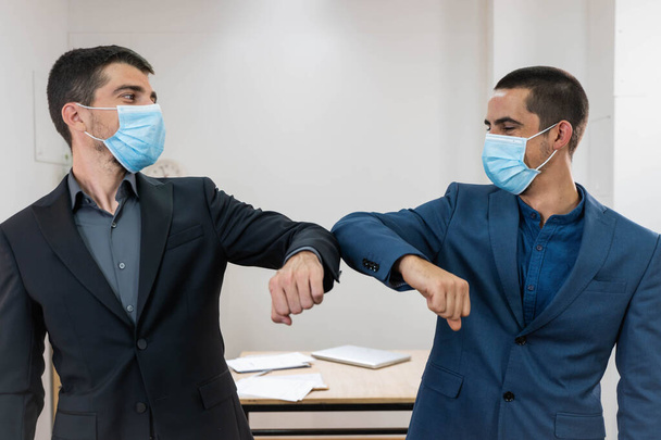 Coronavirus. Business workers elbow greeting in a white background. Elbow greeting because coronavirus. Business workers back to work in office after lockdown. - Foto, Imagen