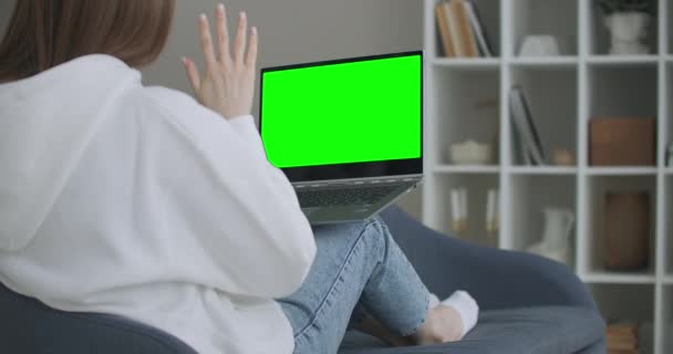 Žena doma sedí na gauči Pracuje na notebooku s Green Mock-up obrazovce. Coronavirus Covid-19 karanténní dálkové vzdělávání nebo pracovní koncept. Dívka používající počítač, prohlížení - Záběry, video