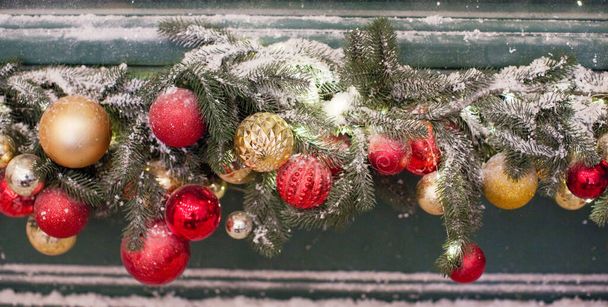 Ghirlanda natalizia con decorazioni rosse e dorate e neve - Foto, immagini