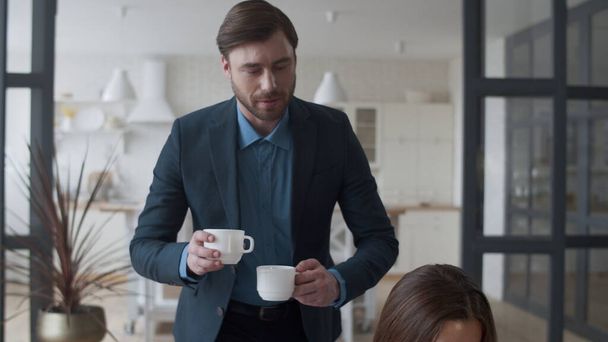 Atraktivní manžel přináší šálek čaje manželce domů. Žena mluví s mužem. - Fotografie, Obrázek